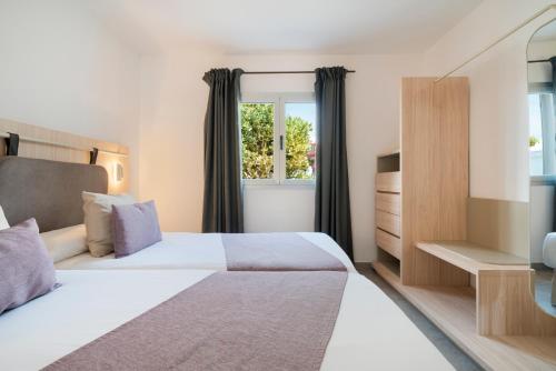 sypialnia z dużym łóżkiem i oknem w obiekcie Apartamentos Santa Rosa w Costa Teguise