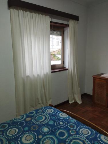 a bedroom with a bed and a window at Casa da estação in Afife