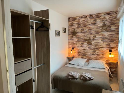 une chambre avec un lit et un mur de briques dans l'établissement Le Clos Saint Patrick, à Dinard