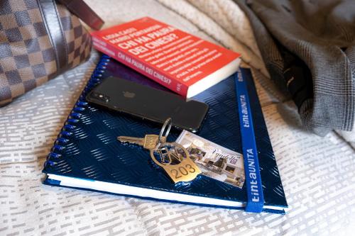 three books sitting on a bed with a key at Hotel Vandelli in Pavullo nel Frignano