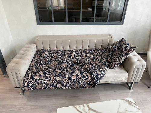 a couch with a blanket on it in a living room at Tain centre -T3- wine themed apartment in Tain-lʼHermitage