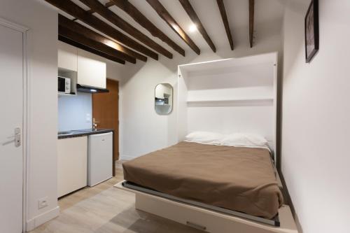 a bedroom with a bed in a white room at Hôtel Léonard de Vinci II in Paris