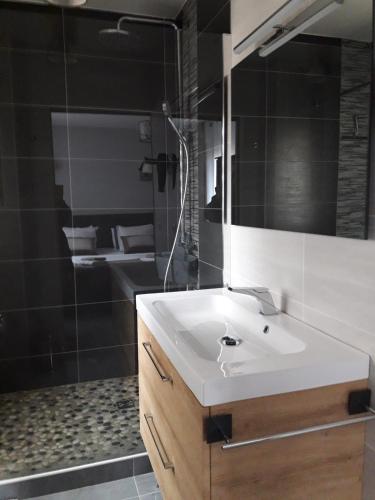 une salle de bain avec un lavabo blanc et un miroir dans l'établissement Mas des criques, à Collioure