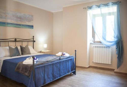 una camera da letto con un letto con lenzuola blu e una finestra di La Tempa del Padrone, Corleto Monforte a Bellosguardo
