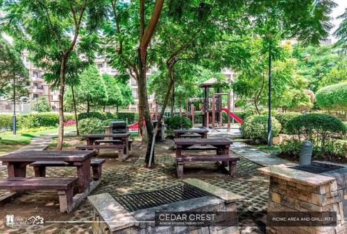 a park with wooden picnic tables and a playground at NestNook in Acacia Estates in Manila