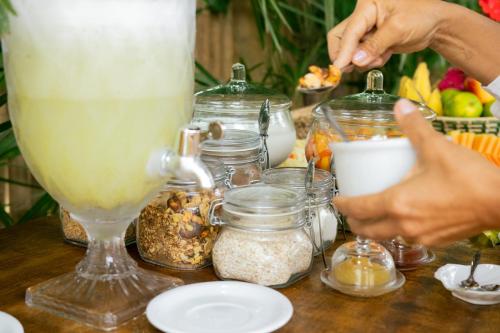 a table with a drink and jars of food at CasaLô Hotel in Jericoacoara