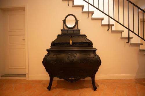 a black vase with a mirror on top of it next to a staircase at Palazzo Doni by Florence Art Apartments in Florence