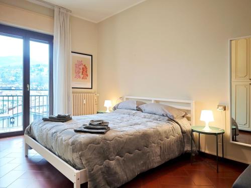 a bedroom with a bed with two lamps and a balcony at 2D Lake View in Verbania