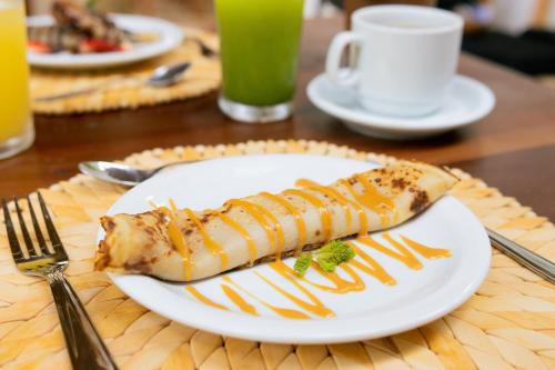 a white plate with a piece of food on a table at CasaLô Hotel in Jericoacoara