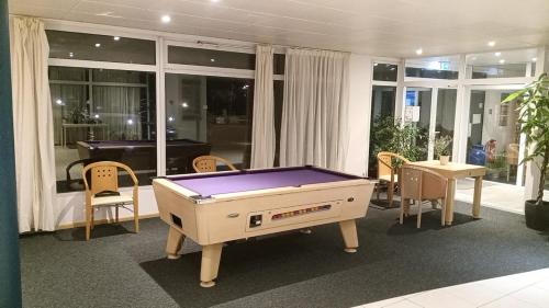a pool table in a room with a table and chairs at Le Roi du Sundgau près de la Horse - Mooslargue in Mooslargue