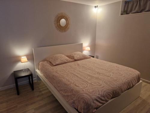 ein Schlafzimmer mit einem Bett und einem Spiegel an der Wand in der Unterkunft Appartement RDC Centre Cabourg in Cabourg