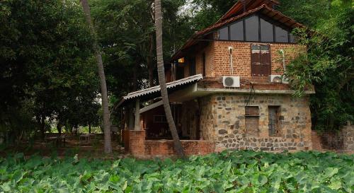 a brick building in the middle of a field at Pathayam Inn in Tiruvannāmalai