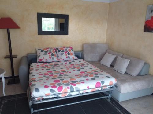 a bed and a couch in a living room at Rez-de-jardin 50 m² entre Biarritz et Capbreton in Ondres