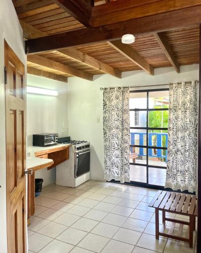 a kitchen with a table and a stove and a window at Bananaquit Tobago -Stay Near the Beach in Crown Point