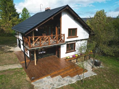 a small house with a porch and a deck at Къща за гости Клонката in Dŭlbok Dol