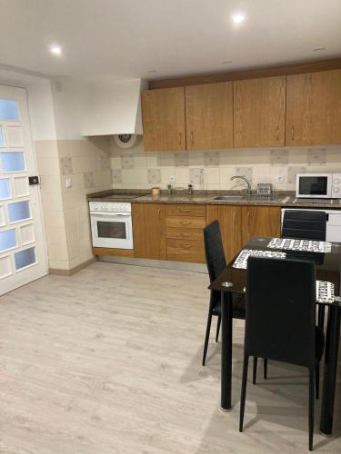a kitchen with a table and chairs and a stove at Casinha da Avenida in Minde