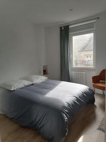 Un dormitorio con una cama grande y una ventana. en Marine 3, en Cherbourg-en-Cotentin