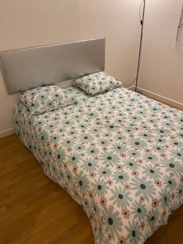 - une chambre avec un lit et une couette en fleurs dans l'établissement Superbe appartement près du stade de France, à Saint-Denis