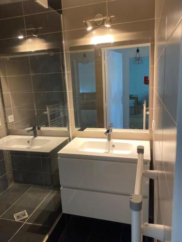 une salle de bain avec deux lavabos et un miroir dans l'établissement Superbe appartement près du stade de France, à Saint-Denis