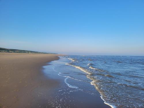 a beach with the ocean and the shoreline at Het Waterhof in Leiden