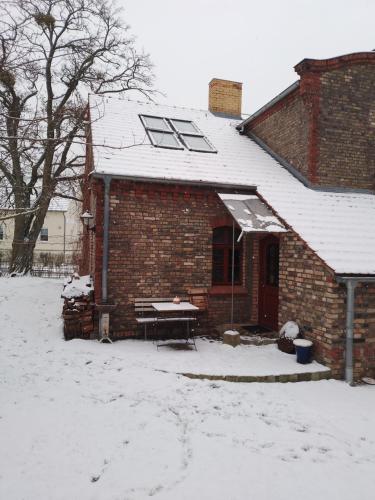 a brick house with a snow covered roof at Quartier im Gutshaus in Wustermark