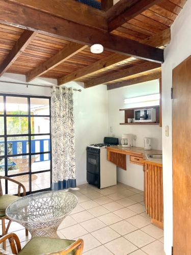 a kitchen with a table and a dining room at Bananaquit Tobago -Stay Near the Beach in Crown Point
