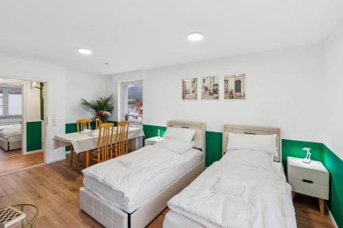 a bedroom with two beds and a dining room at Geschäftsreisetraum 3SZ 5P - SmartTV in Oberkochen