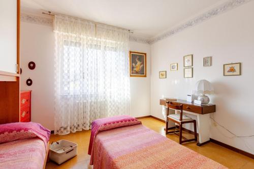 a bedroom with two beds and a desk and a window at CasaPiergiulia - Canzo - Lago di Como -Parcheggio - Wifi in Canzo