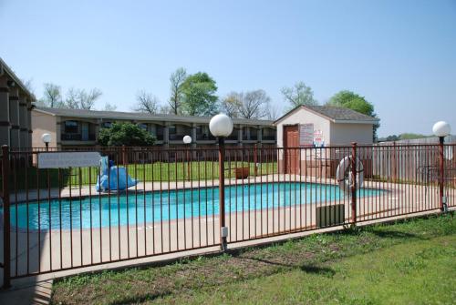 a fence around a swimming pool in a yard at Apple Tree Inn in Lindale