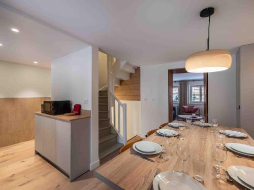 une salle à manger avec une table et des verres à vin dans l'établissement Chalet moderne 4 ch, proche pistes & commerces, animaux admis, WiFi - FR-1-566-75, à Les Allues