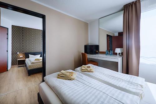 a hotel room with a bed and a mirror at REGIOHOTEL Leipzig West in Schkeuditz