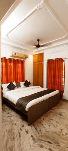 a bedroom with a large bed with orange curtains at Mahuri home stay in Visakhapatnam