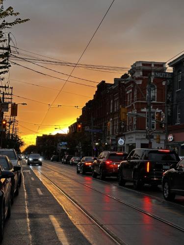 a city street filled with lots of traffic at sunset at Queen Nest Hotel in Toronto