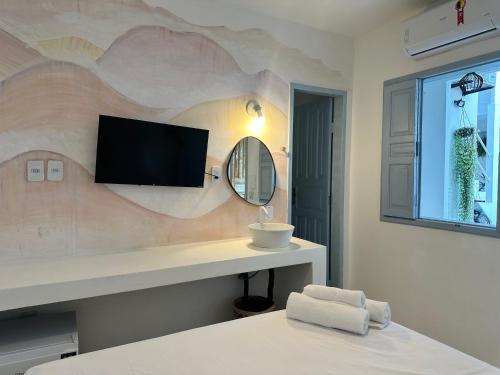 a bedroom with a tv on a wall at Pousada Vilab in Arraial d'Ajuda