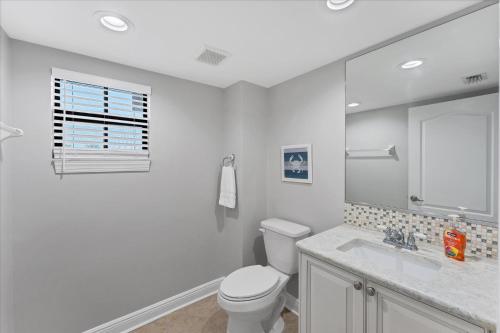 a white bathroom with a toilet and a sink at 50 Meredith #7 in Manasota Key