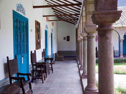 a hallway with chairs and blue doors on a building at San Agustin Monasterio de la Recoleta in Urubamba