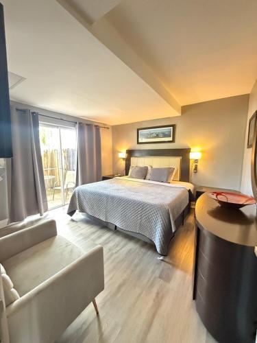 a large bedroom with a bed and a couch at Sheridan Suites Apartments in Dania Beach