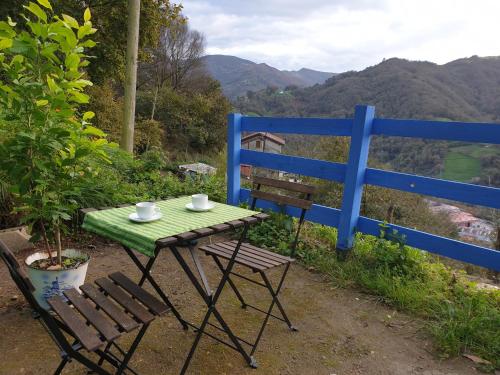 a table and two chairs and a blue fence at Casita de Aldea in Sotrondio
