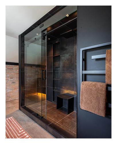 a glass shower with a stool in a room at Experience the Romance of The Historic Rouse House in Bozeman
