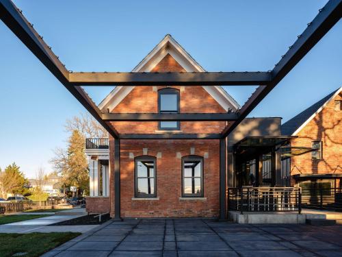 a brick building with a triangular roof at Experience the Romance of The Historic Rouse House in Bozeman