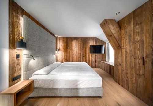 a bedroom with a large bed and wooden walls at Villa Pana in Santa Cristina Gherdëina