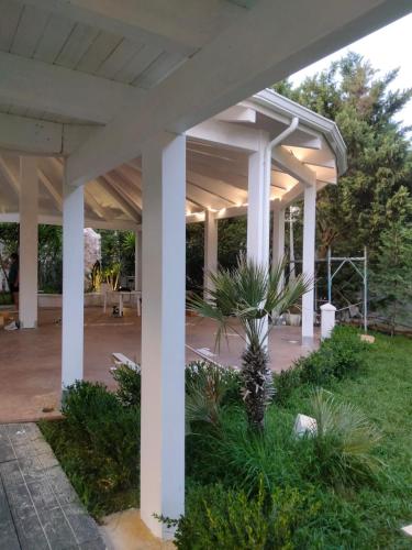 a large covered patio with white columns at Hotel Borina by Isola dei sapori in Foce Varano