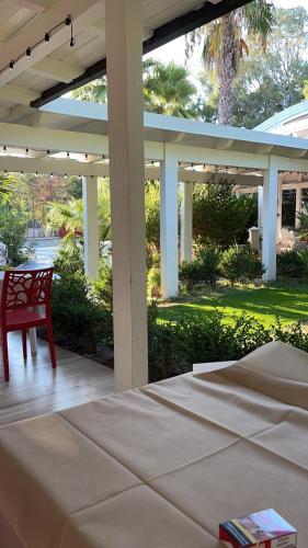 a porch with a bed and a red chair at Hotel Borina by Isola dei sapori in Foce Varano