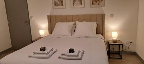 a bedroom with a white bed with towels on it at Pacific Green-80M2-Clime-2 big Suites-Parking privé 2 cars-Jardin-Confort in Chalifert