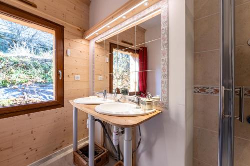 a bathroom with two sinks and a mirror at Le Genepi les Menuires Val Thorens in Praranger