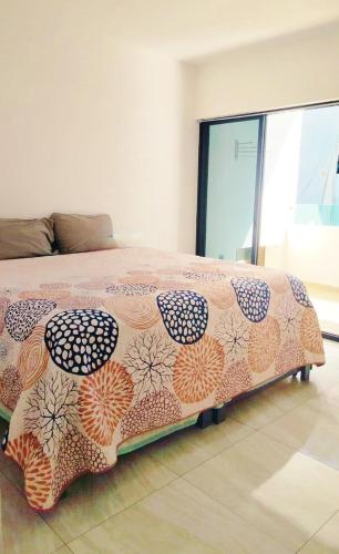 a bedroom with a bed with a patterned blanket on it at Marina Cerritos Coral del Mar - 4 Albercas de Lujo - 1 Min Playas in Mazatlán