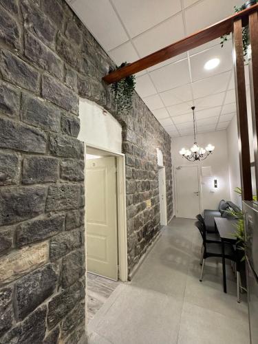 a room with a brick wall and a table and chairs at City Stay Tiberias - סיטי סטיי טבריה in Tiberias
