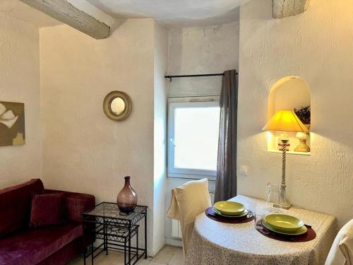 un salon avec une table et un canapé rouge dans l'établissement GALLIENI - Cozy studio in Nice city center, à Nice