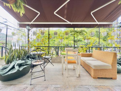 a patio with a couch and chairs and a table at Santiago DC Hotel in Cali