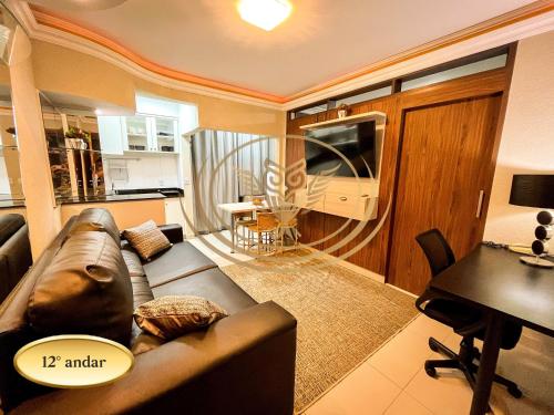 a living room with a brown couch and a kitchen at Coruja Imob - Flat Crystal Place in Goiânia